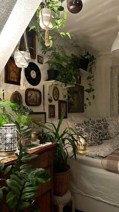 a bedroom with plants and pictures on the wall