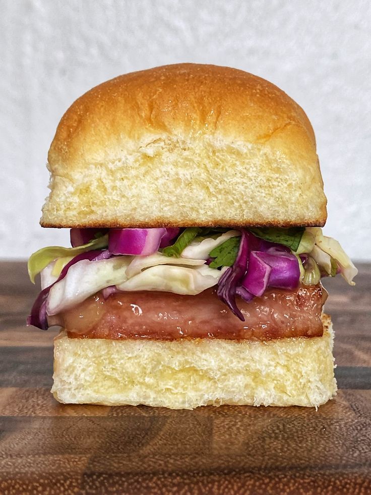 a sandwich with meat, lettuce and onions