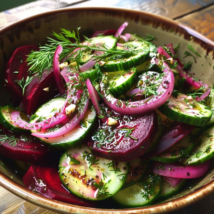 a bowl filled with sliced up vegetables on top of a wooden table