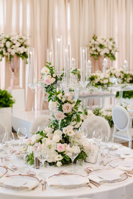 the table is set with white and pink flowers