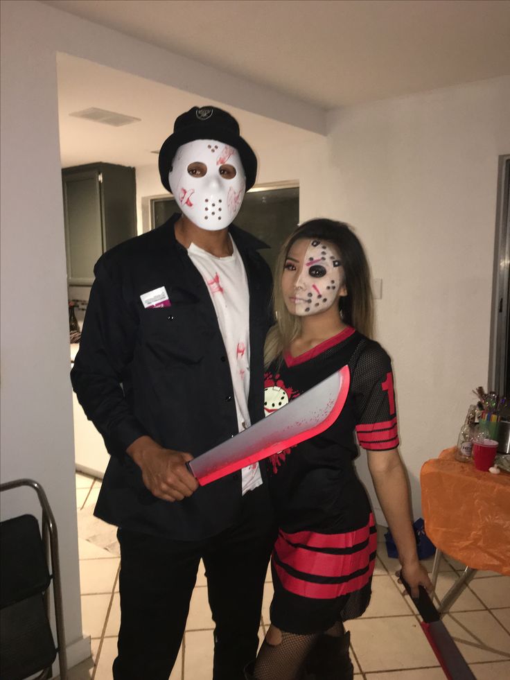 a man and woman dressed up in halloween costumes, one holding a knife while the other is wearing a mask