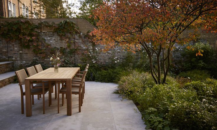 an outdoor dining area with wooden table and chairs