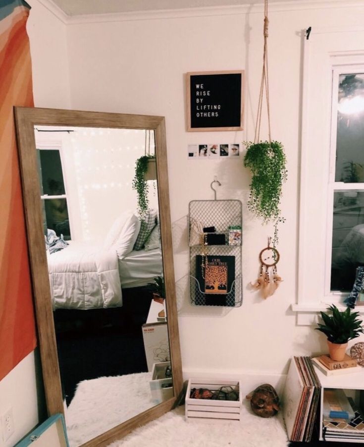 a bedroom with a mirror, plant and other items on the floor in front of it