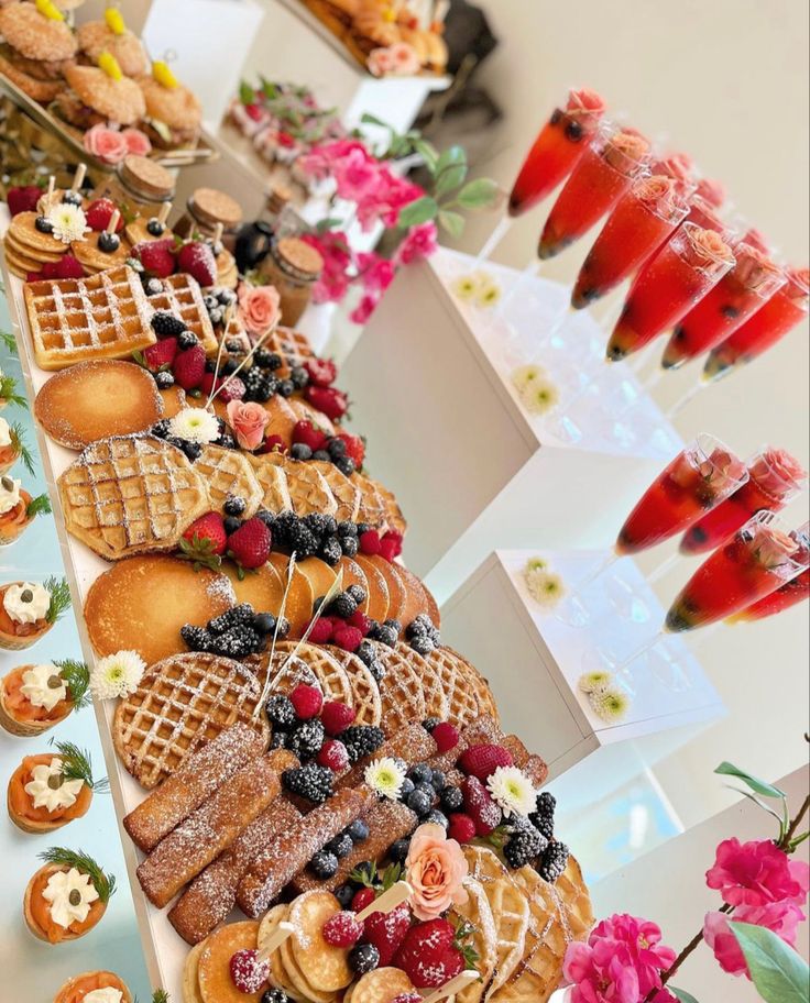 a table topped with lots of waffles covered in fruit