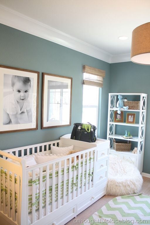 a baby's room with blue walls and pictures on the wall