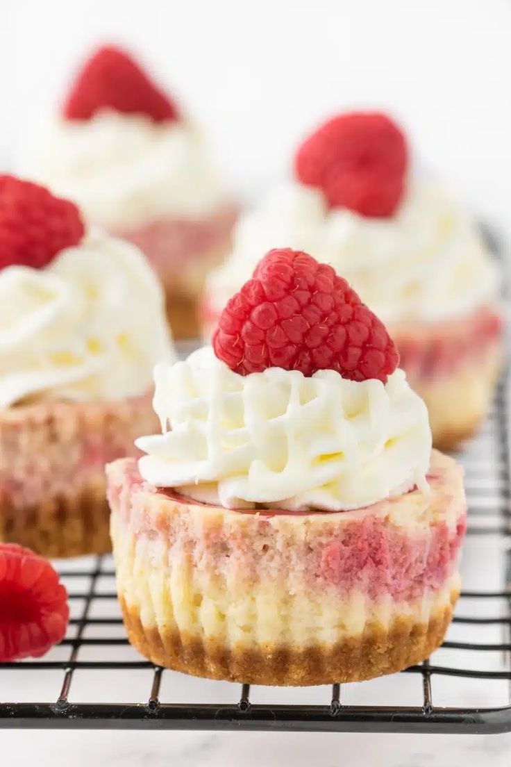 raspberry cheesecake cupcakes on a cooling rack