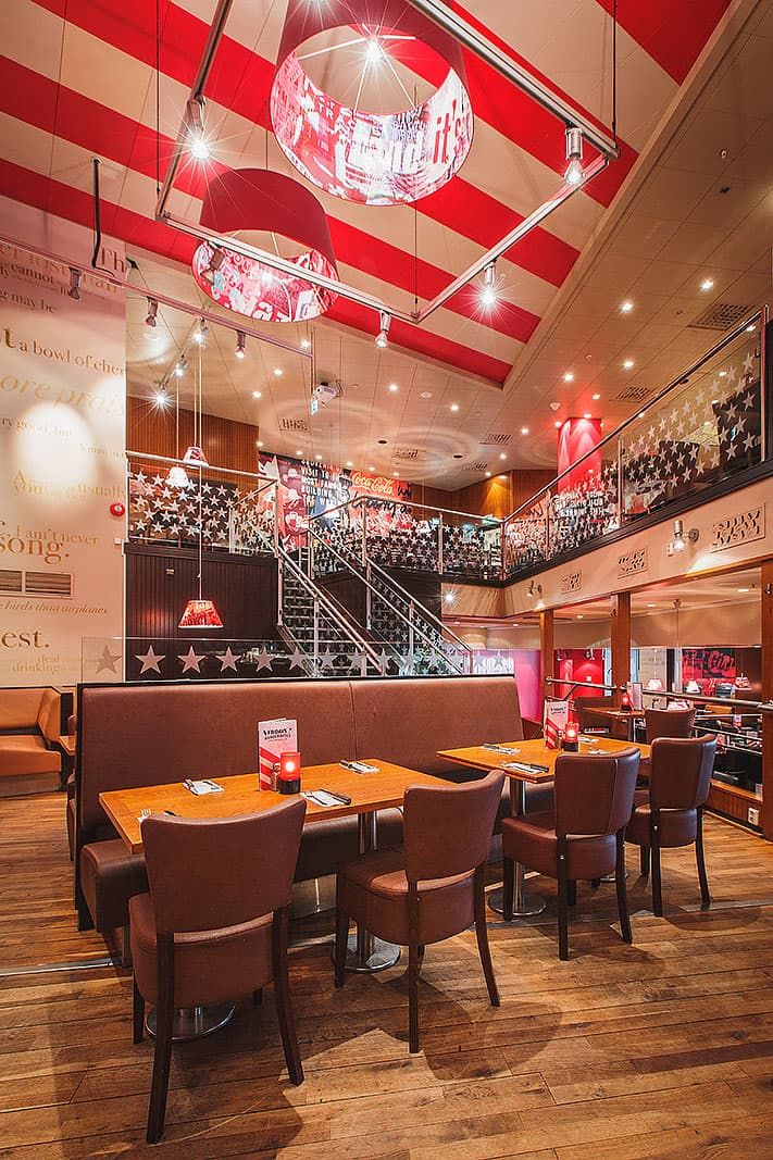 an empty restaurant with red and white striped ceiling