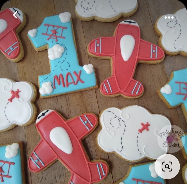 decorated cookies are arranged in the shape of airplanes