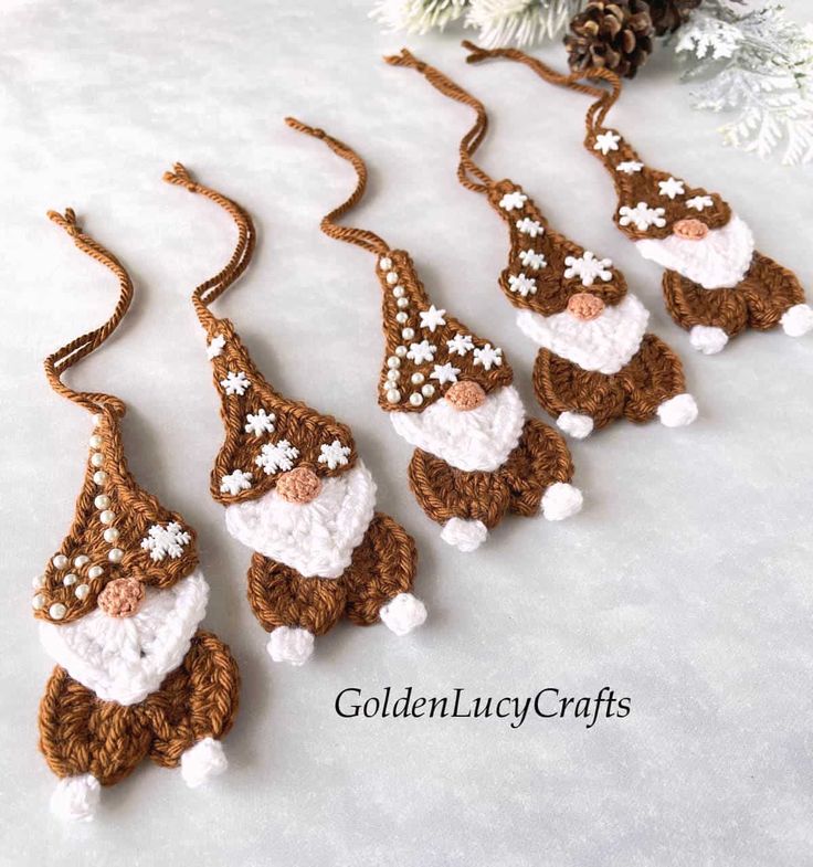 crocheted christmas ornaments with santa hats and snowflakes hanging from the strings