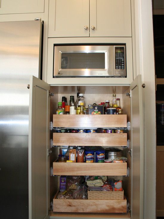 an open refrigerator in a kitchen next to a microwave