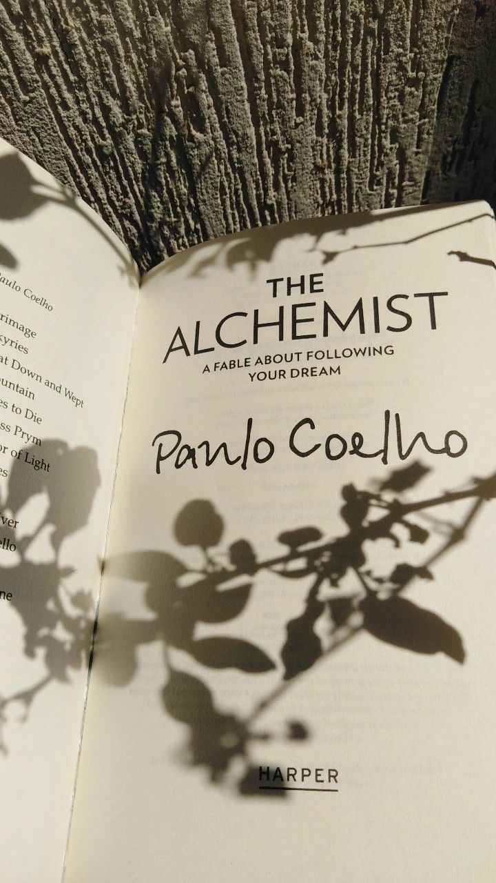 an open book with the title of the alchemist by pando corlello