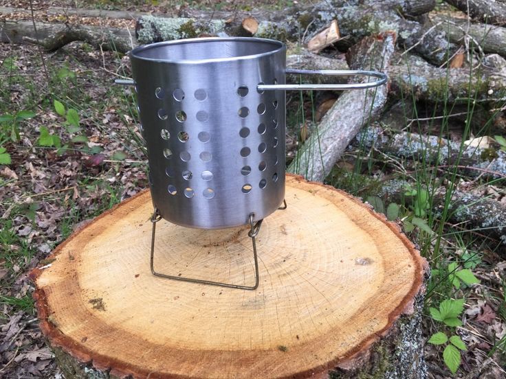 a metal pot sitting on top of a tree stump