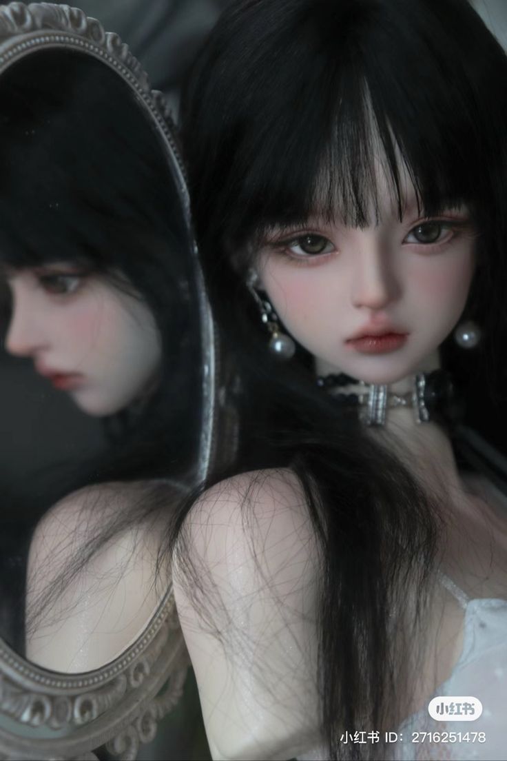 a doll with black hair is looking at herself in the mirror