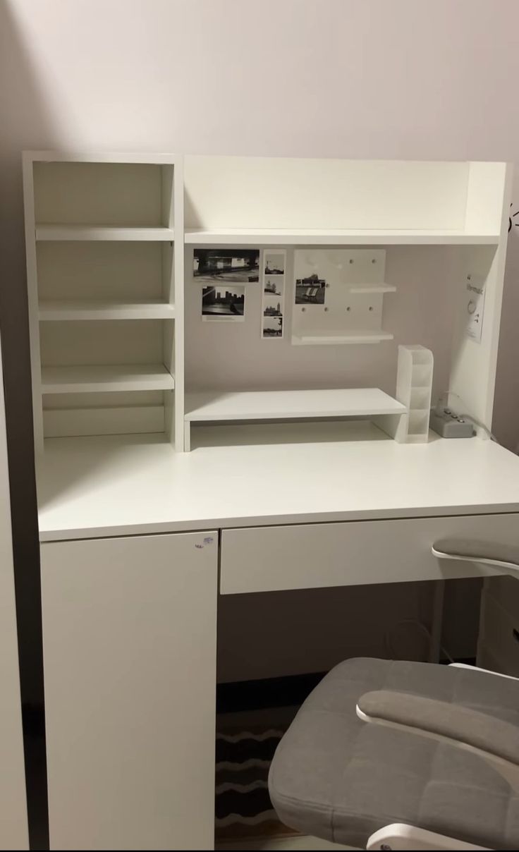 a white desk with a chair in front of it and shelves on the wall behind it