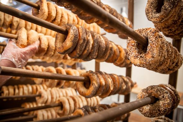 doughnuts are lined up on racks in a bakery, ready to be baked