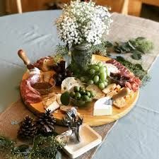 a platter filled with assorted cheeses and meats on a table cloth