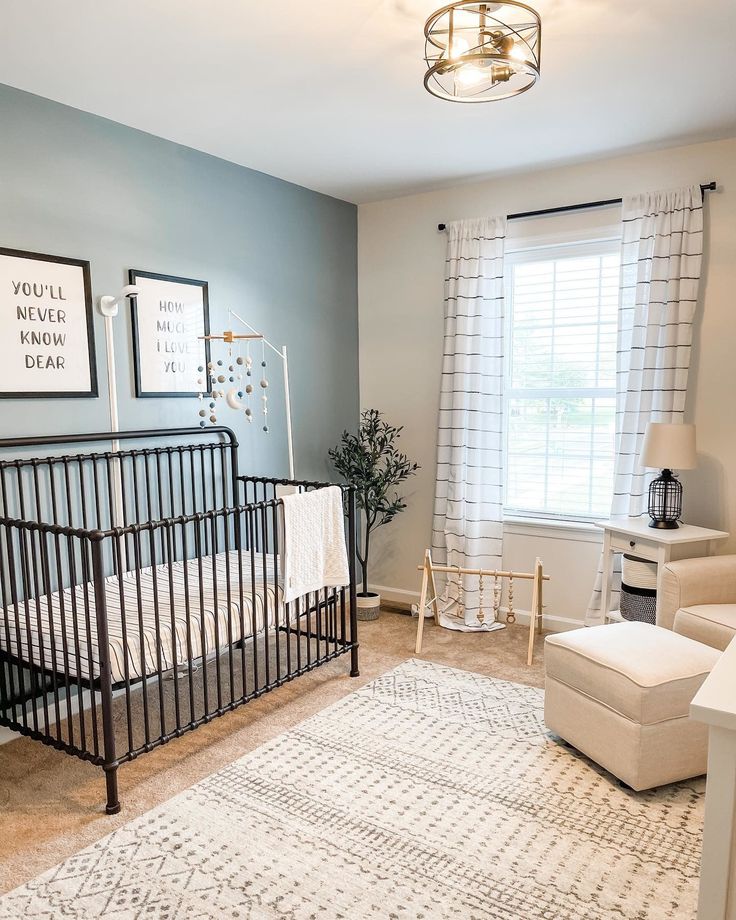 a baby's room with a black crib and white rug