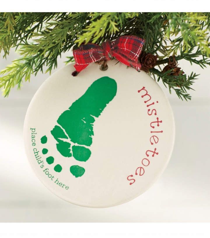 an ornament hanging from a christmas tree with a handprinted foot on it