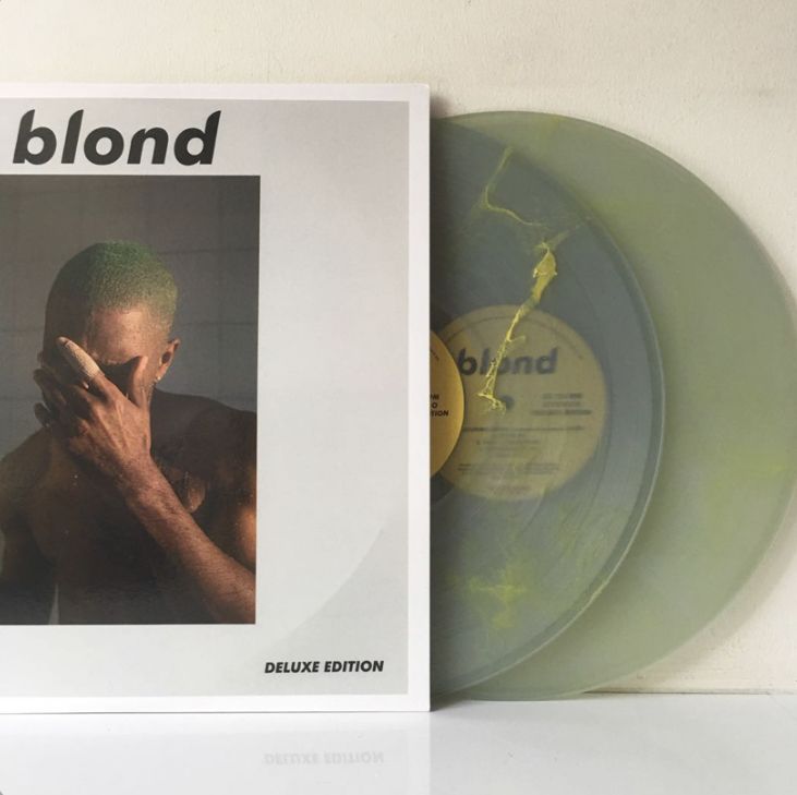 a green vinyl record sitting on top of a white table next to an album cover