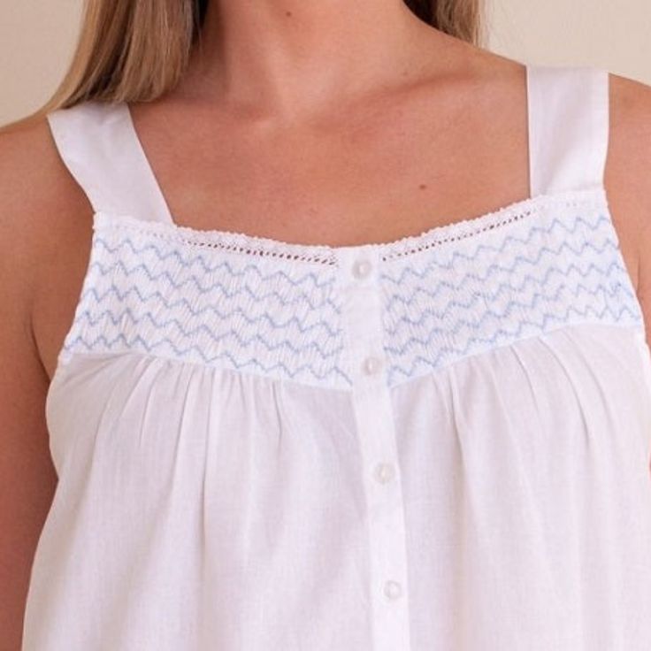 Made with crisp 100% cotton, the sleeveless Vicki nightgown is a favorite for evenings at home. Effortless luxury for laid-back lounging, this nightgown features beautiful blue smocking on the bodice, a ruffled hem and four buttons down the front. Also great for pregnancy and breastfeeding mothers! Product Overview: Sizing information: XSmall (US 0) Small (US 2-4) Medium (US 6-8) Large (US 10-12) XLarge (US 14-16) Design: Strap Sleeves and Ruffle Hem Embroidery: Soft Blue Smocking on Bodice White Cotton Nightgown, Hem Embroidery, Outdoor Umbrella Stand, Accent Chair Bedroom, Cotton Nightgown, Kurta Neck Design, Blue And White Style, Women's Nightgowns, Nightgowns For Women