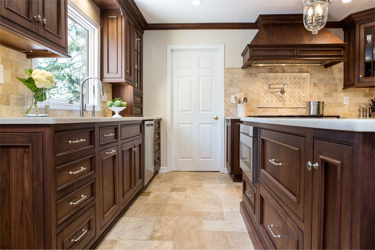 a large kitchen with wooden cabinets and marble counter tops, along with a white door