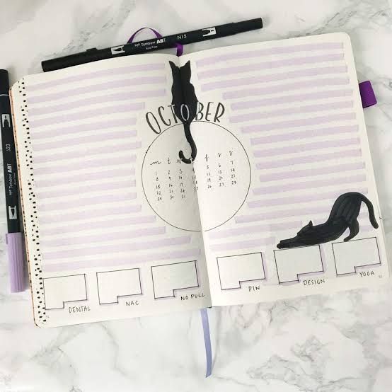 an open planner with a cat on it and the words october written in cursive writing