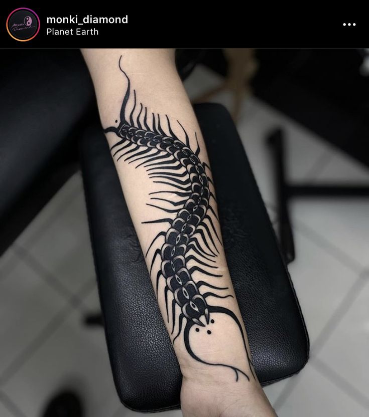 a black and white photo of a tattoo on someone's arm that has a scorpion on it