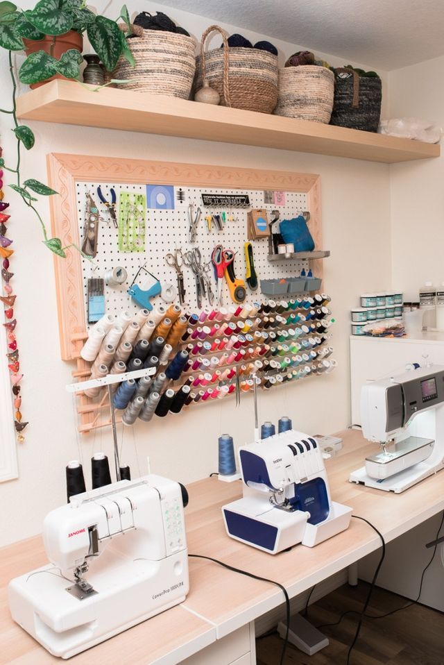 a sewing room with several machines and baskets on the wall