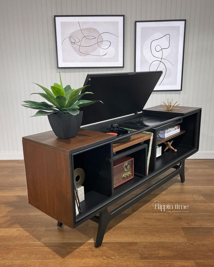 an open laptop computer sitting on top of a wooden cabinet