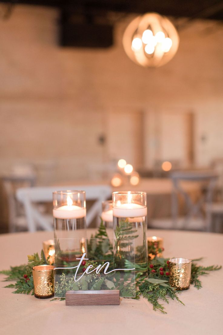 a table with candles and greenery on it