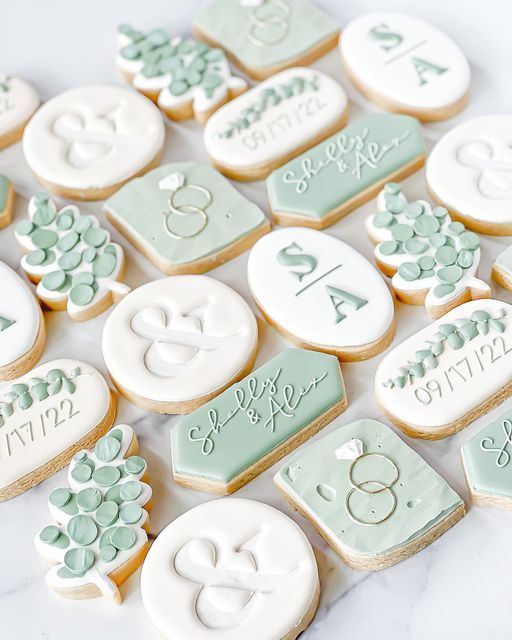 decorated cookies are arranged on a marble surface