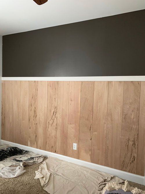 an empty room with wood paneling on the wall