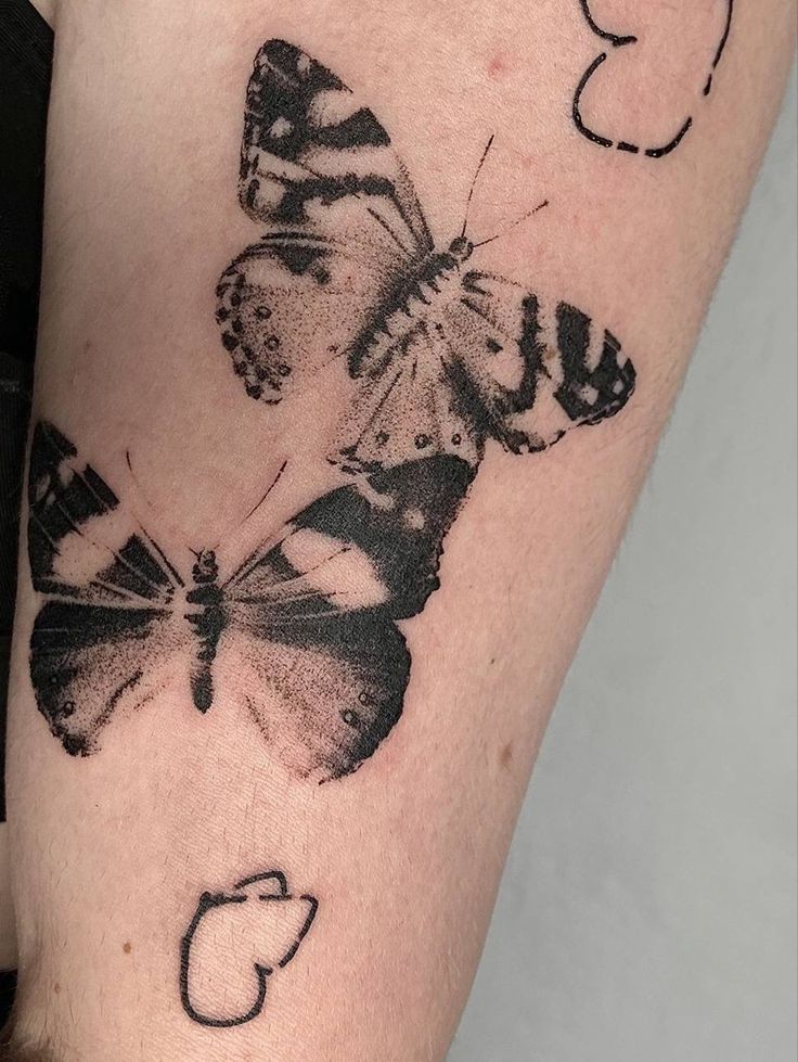 a black and white butterfly tattoo on the right arm with numbers 3, 5, and 6