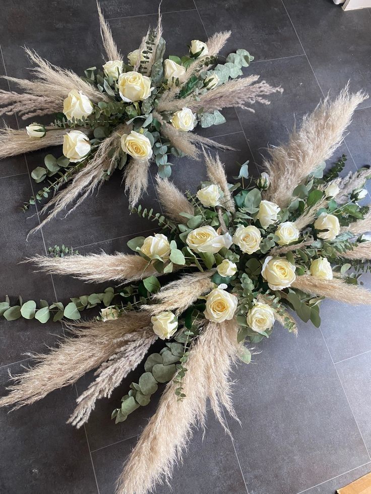 some flowers are laying on the floor next to eachother with long grass and white roses