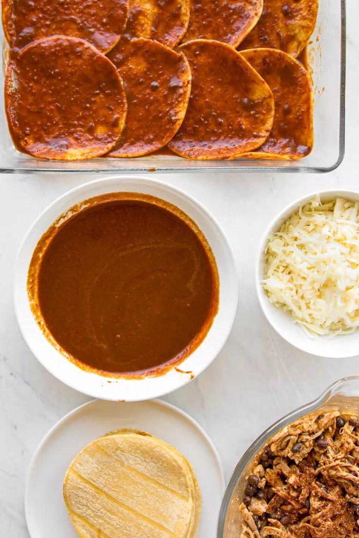 the ingredients for an enchilada casserole laid out on a table