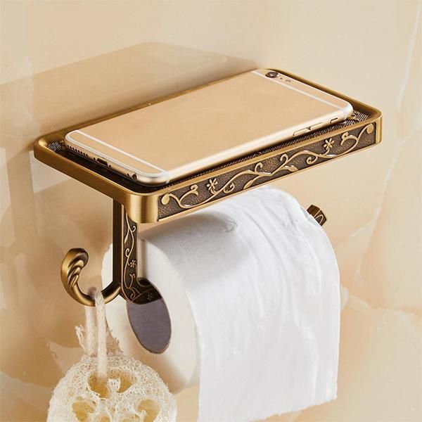 a cell phone is hanging on the wall next to a roll of toilet paper and a tablet