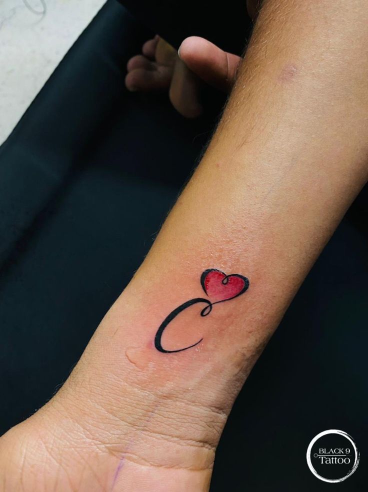 a small heart tattoo on the wrist