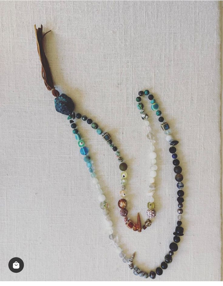 Embrace the spirit of adventure with our Travel Mala. Crafted from various precious and semi-precious gems collected from around the world, each bead is intentionally placed in an ombré style and hand-knotted. The guru bead and tassel are available in multiple options, allowing for personal customization. Each Mala takes 3-5 hours to assemble, symbolizing gypset travel adventures and featuring unique beads, shells, and seeds from different parts of the world. Every necklace is one-of-a-kind, and Adjustable Gemstone Beaded Crystal Necklace, Adjustable Round Bead Mineral Crystal Necklaces, Adjustable Mineral Crystal Necklace With Gemstone Beads, Adjustable Mineral Crystal Round Beads Necklace, Bohemian Labradorite Beaded Necklace, Bohemian Labradorite Beaded Crystal Necklace, Bohemian Labradorite Beaded Crystal Necklaces, Bohemian Labradorite Beaded Necklace With Natural Stones, Bohemian Beaded Labradorite Crystal Necklaces