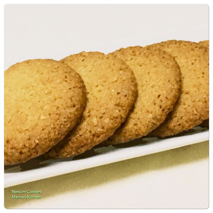 four cookies are arranged on a white platter and ready to be eaten or served