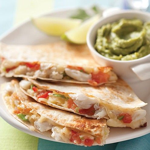 a plate topped with quesadillas and guacamole