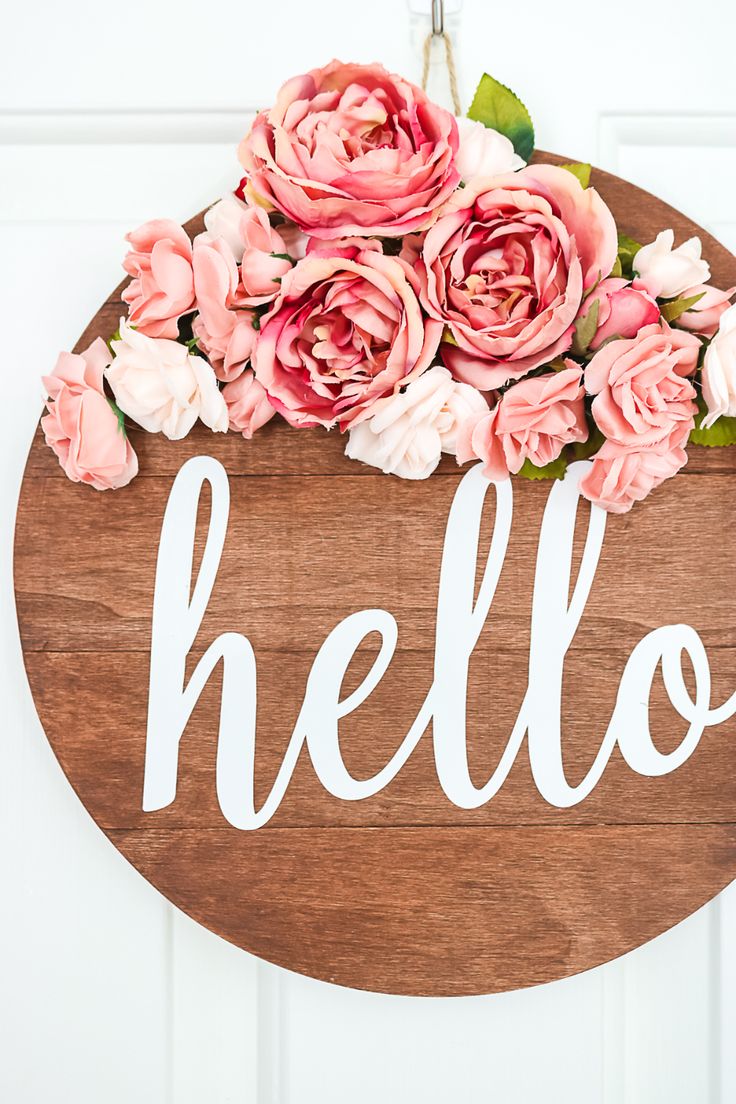 a wooden sign that says hello with pink flowers on it and the words floral wreath