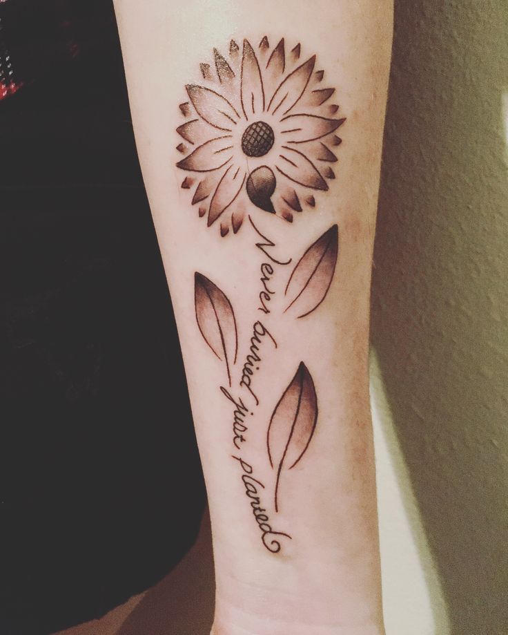 a woman's arm with a flower tattoo on it