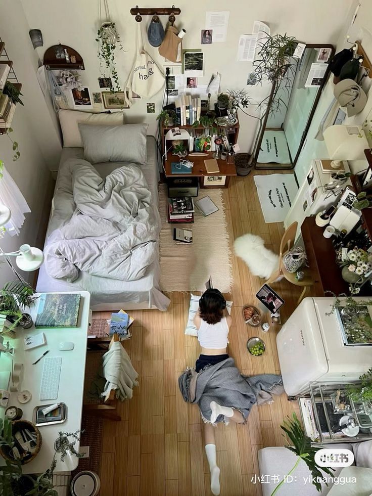 a woman sitting on the floor in front of a bed