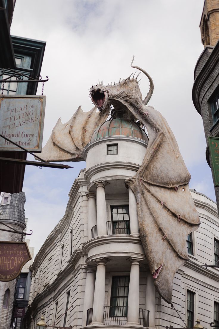 a large white building with a giant dragon statue on it's roof and windows