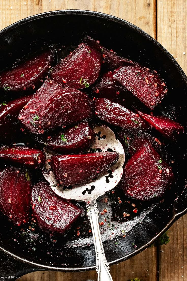 cooked beets in a skillet with a spoon