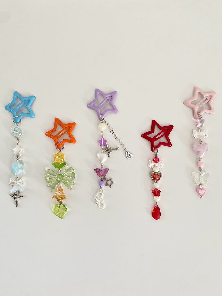 six different colored stars and beads on a white surface