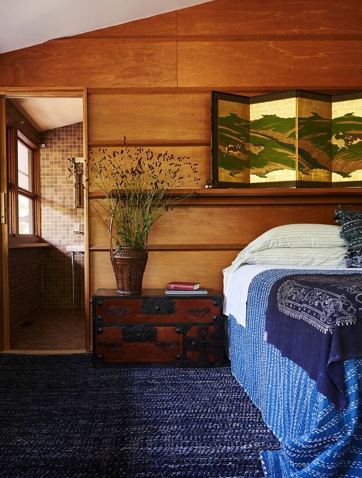 a bedroom with wood paneling and blue carpet