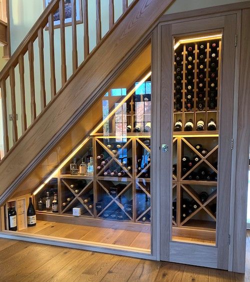 a wine cellar under the stairs in a house