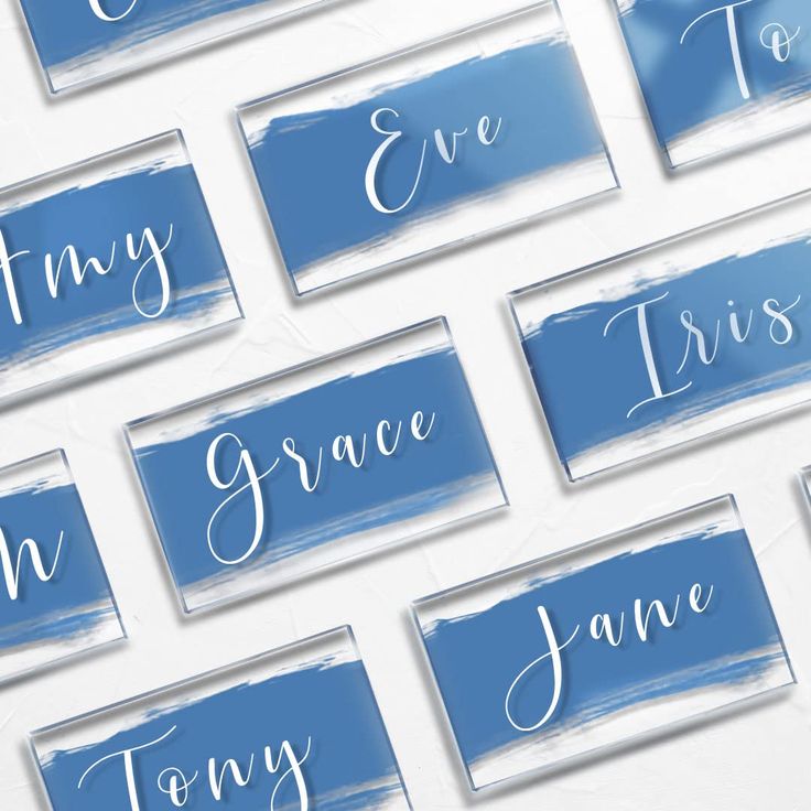 blue watercolor name tags with white lettering and brush strokes on the back of them