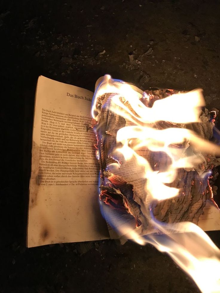 an open book with flames coming out of it